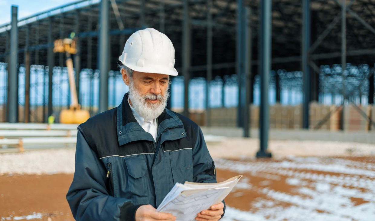 Engineer examining building plans outdoors