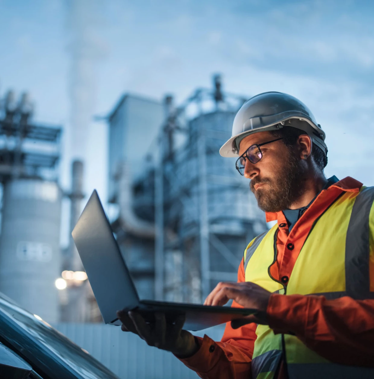 Man in hard hat inspecting data onsite.